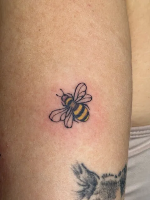 Tatuagem fine line de abelha no braço, Kaoma Ferraz, Alvalade, Lisboa